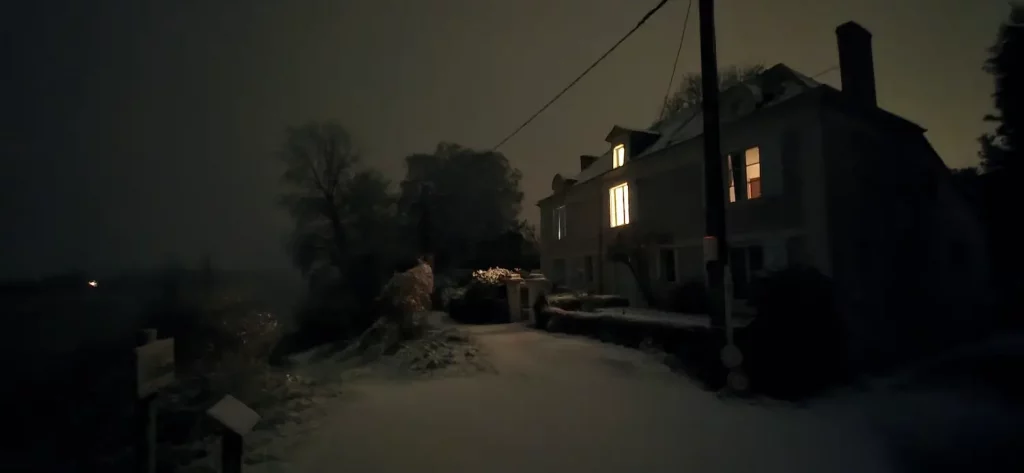 Photo prise de nuit d'une maison de Béhuard, un soir de neige.