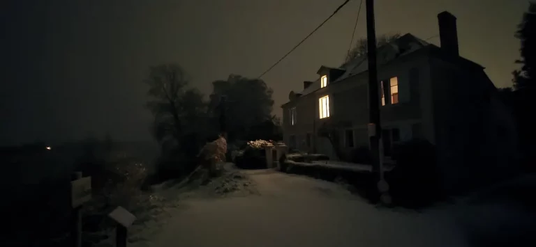 Photo prise de nuit d'une maison de Béhuard, un soir de neige.